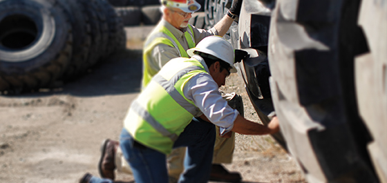 trabajadores de campo inspeccionando neumáticos OTR