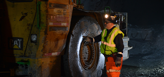 terenski delavec ocenjuje pnevmatiko OTR na gradbenem stroju