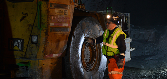 field worker evaluating an OTR tire on construction machinery